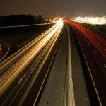 Abstrakte Lichtspuren auf einer nächtlichen Landstraße.