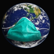 Globe draagt een gezichtsmasker om de COVID-19 pandemie voor te stellen. 